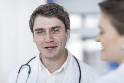 Smiling doctor talking to woman in hospital stock photo