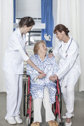 Arzt und Krankenschwester kümmern sich um einen älteren Patienten im Rollstuhl - ZEF007275