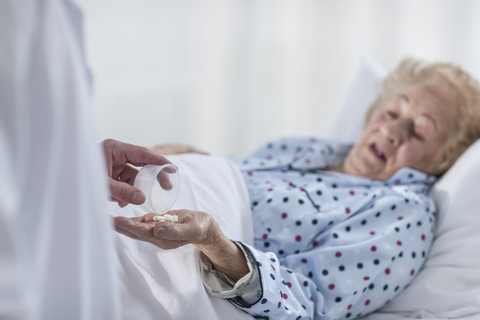 Patient lying in hospital bed receiving medication stock photo