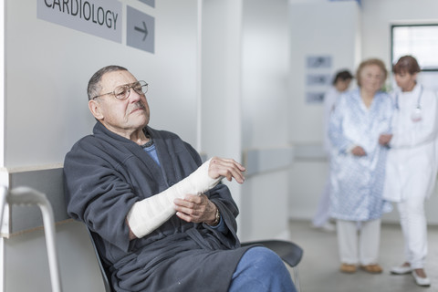 Elderly patient with arm bandage waiting in hospital stock photo