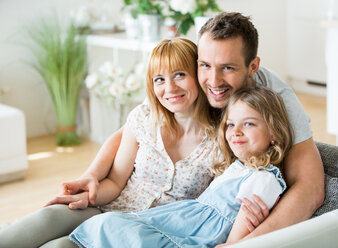 Happy family sitting on couch - WESTF021495