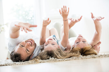 Glückliche Familie, die auf dem Boden liegt und herumalbert - WESTF021526