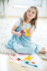 Kleines Mädchen schneidet Osterhasen aus Papier aus - WESTF021542
