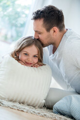 Father and daughter at home, father kissing daughter's hair - WESTF021553