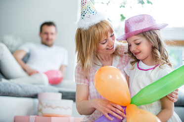 Familie feiert mit Luftballons und Partyhüten - WESTF021576