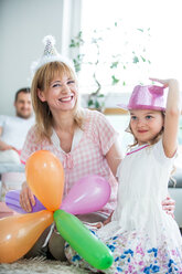 Familie feiert mit Luftballons und Partyhüten - WESTF021578