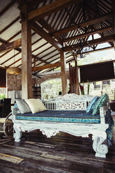 Indonesia, Bali, wooden classic Indonesian daybed in a holiday villa - MBEF001400