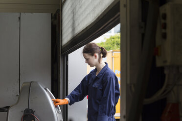 Junge Frau arbeitet in einer Reparaturwerkstatt - SGF001808