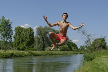 Germany, Bavaria, teenage boy jumping into River Loisach - LBF001161