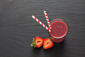 Ein Glas Erdbeer-Smoothie und eine in Scheiben geschnittene Erdbeere - CSF025974