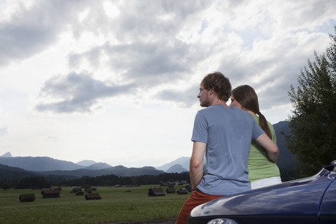 Deutschland, Bayern, Paar neben Auto mit Blick auf die Aussicht, lizenzfreies Stockfoto