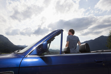 Germany, Bavaria, man next to convertible looking at view - RBF003029