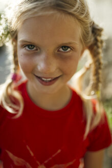 Porträt eines lächelnden kleinen Mädchens mit Zöpfen - MGOF000394