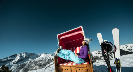 Österreich, Altenmarkt-Zauchensee, Skifahrer im Strandkorb mit Kapuze in den Bergen - HHF005362