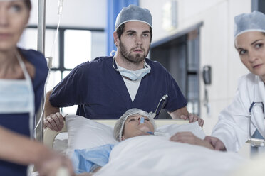 Doctors pushing a bed with patient - ZEF007337