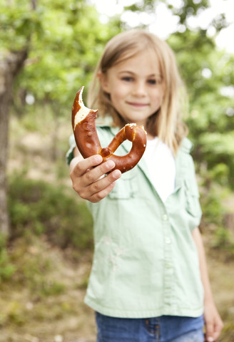 Girl holding bitten pretzel stock photo