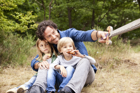 Father with two children in the nature holding wooden sword stock photo
