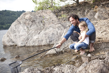 High angle view of father and daughter fishing in lake stock photo