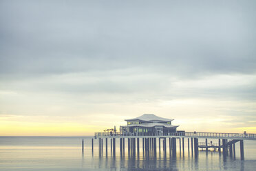 Germany, Niendorf, view to sea bridge with tea house at sunrise - PUF000403