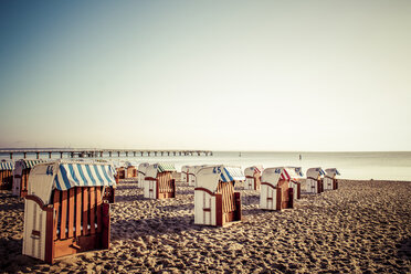 Germany, Niendorf, view to Timmendorfer Strand with hooded beach chairs at sunrise - PUF000401