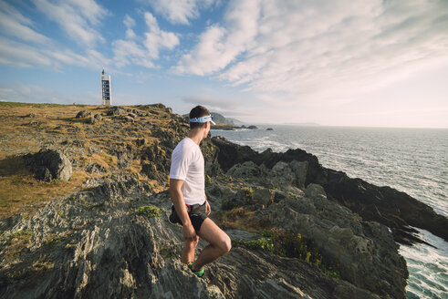 Spanien, Valdovino, junger Mann steht an der Küste und betrachtet die Aussicht - RAEF000249