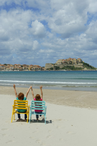 Corsica, Calvi, two children in beach chairs at beach stock photo