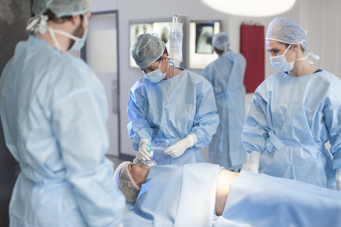 Surgical team anesthetizing patient stock photo