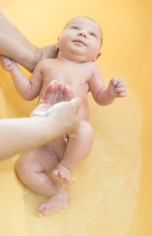 Ältere Frau badet neugeborenes Baby, lizenzfreies Stockfoto