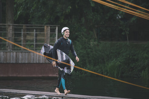 Junger Mann trägt sein Wakeboard - MADF000506