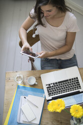 Young woman at home office using digital tablet - RIBF000142