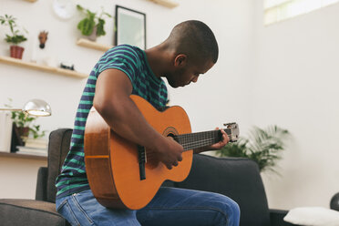 Mann spielt Gitarre zu Hause - EBSF000846