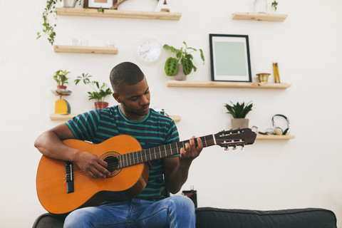 Mann spielt Gitarre zu Hause, lizenzfreies Stockfoto
