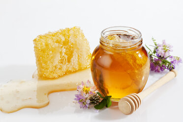 Glass of honey, honeycomb, honey spoon and wild flowers - CSF026024