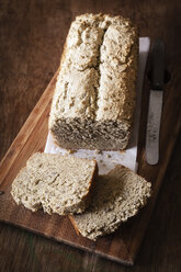 Home-baked wholemeal bread, gluten-free, bread knife on chopping board - EVGF002002