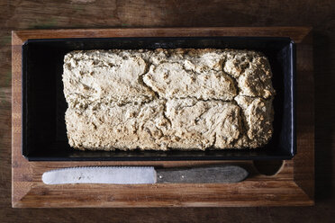 Home-baked wholemeal bread, gluten-free, bread knife on chopping board - EVGF002003