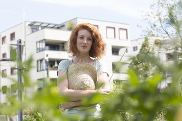 Young woman gardening, urban gardening - SGF001828