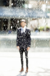 Porträt eines verschwommenen Geschäftsmannes, der hinter einem Springbrunnen steht - PASF000002