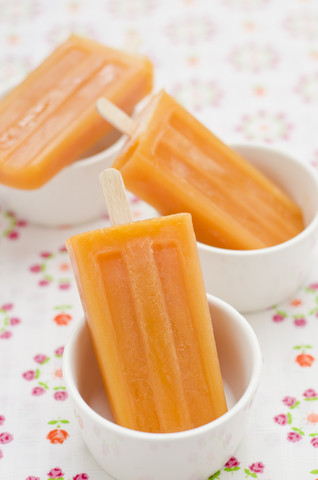 Three bowls with fruit juice ice lollies stock photo