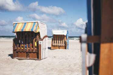 Germany, Mecklenburg-Western Pomerania, Warnemuende, closed hooded beach chairs on the beach - ASCF000296