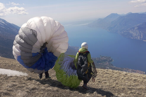 Gleitschirmfliegen, Gleitschirmflieger starten vor dem Gardasee - TMF000028