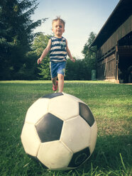 Kleiner Junge spielt Fußball im Hinterhof - ABAF001856