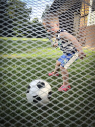 Kleiner Junge spielt Fußball im Hinterhof - ABAF001857