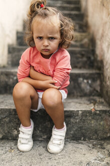 Portrait of little girl sitting on steps pouting mouth - MGOF000403