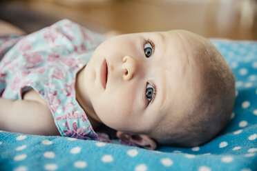 Portrait of baby girl lying on dotted blanket - MFF001955