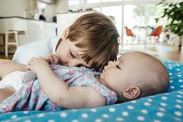 Baby girl and brother cuddling at home - MFF001958