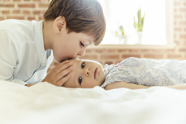 Brother softly kissing his little sister on her forehead - MFF001961