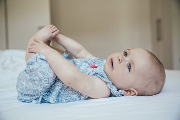 Baby girl lying on her back on bed - MFF001967