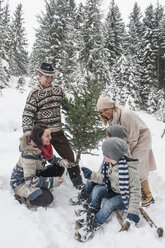 Austria, Altenmarkt-Zauchensee, happy family with Christmas tree in winter forest - HHF005402