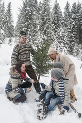 Österreich, Altenmarkt-Zauchensee, glückliche Familie mit Weihnachtsbaum im Winterwald - HHF005402