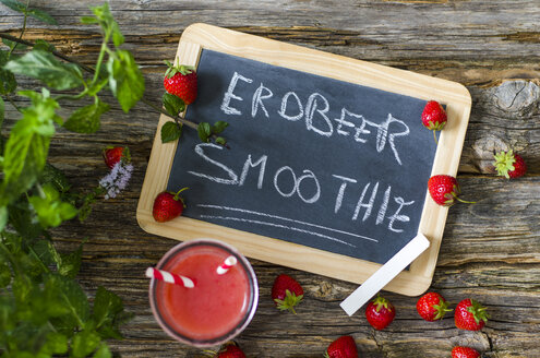 Erdbeer-Smoothie im Glas, Schiefertafel, Erdbeeren und Minze auf Holz - ODF001195